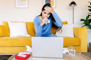 Sick patient making online booking on computer